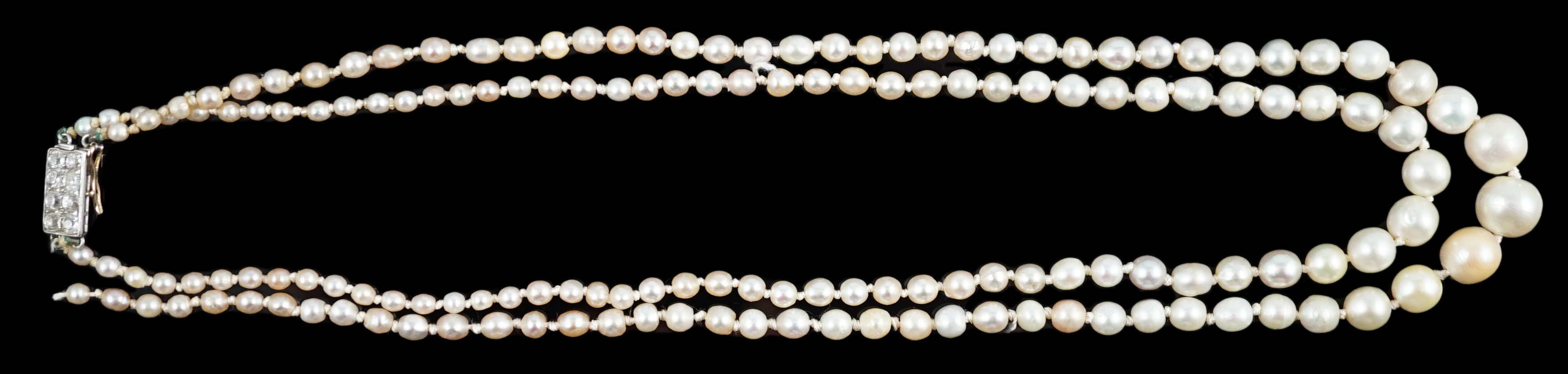A twin strand graduated cultured pearl necklace, with gold and six stone diamond set rectangular clasp